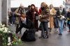 People lay down flowers in tribute to the victims after the official commemorative ceremony for the victims of the deadly fire at the 