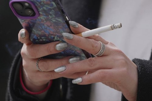 A woman smokes on a street in London on April 16, 2024. (AP Photo/Kin Cheung, File)