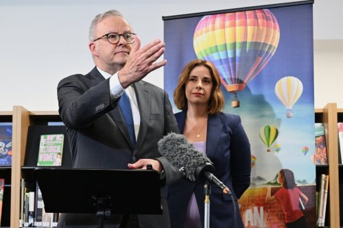 Australian Prime Minister Anthony Albanese, left, and Australian Communications Minister Anika Wells speak to the media during a visit to St John Paul II College in Canberra, Australia, on Dec. 11, 2025. (Lukas Coch/AAP Image via AP)