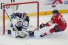 Winnipeg Jets goaltender Eric Comrie (1) stops a shot on goal as Florida Panthers center Sam Bennett (9) defends during the third period of an NHL hockey game, Saturday, Jan. 31, 2026, in Sunrise, Fla. (AP Photo/Marta Lavandier)