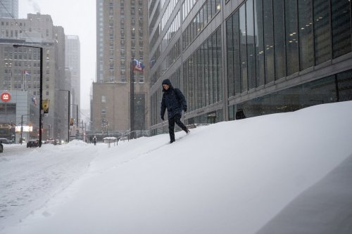 A pedestrian navigates a snowed-in staircase amid heavy snowfall and accumulation as snow and heavy winds continue to hammer the Greater Toronto Area, in Toronto, Thursday, Jan. 15, 2026. THE CANADIAN PRESS/Giordano Ciampini