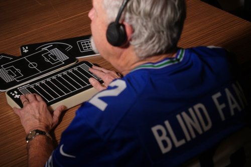 Clark Roberts, a blind Seattle Seahawks fan, uses a OneCourt tablet, a tactile device that translates gameplay into trackable vibrations along with real-time audio, at the T-Mobile Innovation Hub Tuesday, Jan. 27, 2026, in Bellevue, Wash. (AP Photo/Lindsey Wasson)