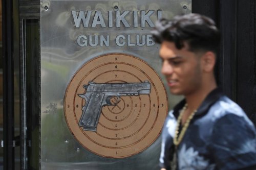 FILE - A pedestrian walks past the Waikiki Gun Club in Honolulu, Thursday, June, 23, 2022. (AP Photo/Marco Garcia)