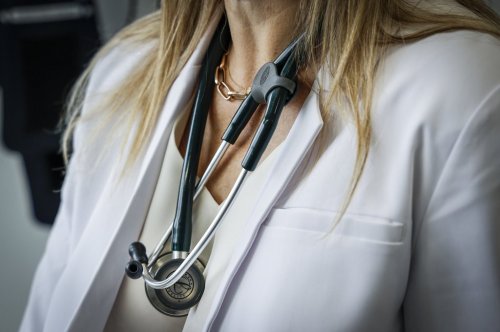 A doctor wears a lab coat and stethoscope in an exam room at a health clinic in Calgary, Friday, July 14, 2023.THE CANADIAN PRESS/Jeff McIntosh