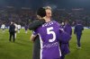 Fiorentina's Rolando Mandragora with a jersey of Fiorentina's President Rocco Commisso, celebrates the victory with Alessandro Ferrari at the end of the Serie A soccer match between Bologna and Fiorentina in Bologna, Italy, Sunday, Jan.18, 2026. (Massimo Paolone/LaPresse via AP)