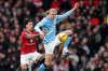 Manchester United's Lisandro Martinez, left, challenges for the ball with Manchester City's Erling Haaland during the English Premier League soccer match between Manchester United and Manchester City in Manchester, England, Saturday, Jan. 17, 2026. (AP Photo/Dave Thompson)