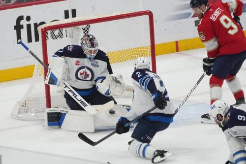 Winnipeg Jets goaltender Eric Comrie (1) stops a shot on goal during the first period of an NHL hockey game against the Florida Panthers, Saturday, Jan. 31, 2026, in Sunrise, Fla. (AP Photo/Marta Lavandier)
