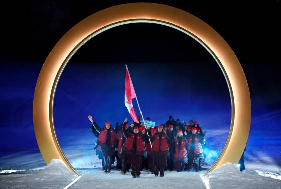 Flag bearers from Canada, Mikael Kingsbury and Marielle Thompson, lead the team Friday during the Olympic opening ceremony at the 2026 Winter Olympics in Livigno, Italy. (Cameron Spencer/Pool photo)