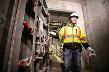 MIKAELA MACKENZIE / FREE PRESS
                                Deputy project director Rob Black demonstrates the submarine doors at the new pump station at the North End wastewater treatment plant on Wednesday.