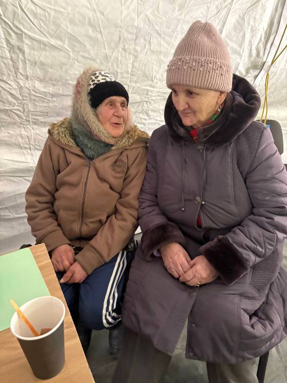Kyiv residents Vira Kurylenko, 75, and Tamila Ivanenko, 70, warm up at emergency warming tents. (Melissa Martin / Free Press)