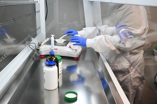 A technician weighs a chemical while preparing a medication under a ventilation hood in a pharmacy laboratory in Quebec City, Wednesday Feb. 5, 2025. THE CANADIAN PRESS/Jacques Boissinot