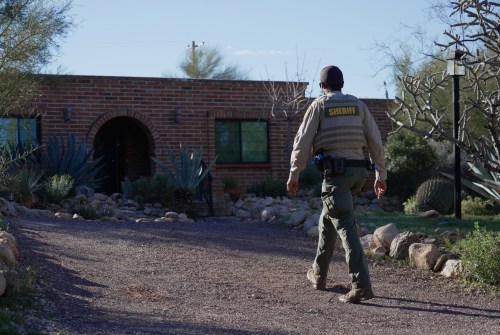A member of the Pima County sheriffs office remains outside of Nancy Guthrie's home, Monday, Feb. 9, 2026 in Tucson, Ariz. (AP Photo/Ty ONeil)