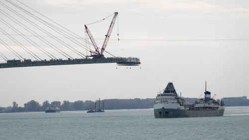 FILE - The Saginaw passes construction on the Gordie Howe International Bridge connecting on the Detroit River connecting Windsor, Ontario and Detroit, Oct. 25, 2023. (AP Photo/Paul Sancya, File)