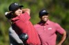 FILE- Charlie Woods tees off on the fifth hole as his father Tiger Woods watches during the final round of the PNC Championship golf tournament on Dec. 22, 2024, in Orlando, Fla. (AP Photo/Phelan M. Ebenhack, File)
