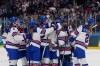 US players celebrate at the end of a preliminary round match of women's ice hockey between USA and Canada at the 2026 Winter Olympics, in Milan, Italy, Tuesday, Feb. 10, 2026. (AP Photo/Petr David Josek)