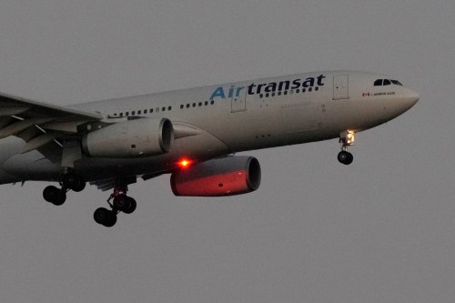An Air Transat Airbus A330 approaches for landing in Lisbon just before sunrise, Monday, July 22, 2024. (AP Photo/Armando Franca)
