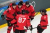 Canada's Connor McDavid celebrates with teammates after scoring his sides first goal during a preliminary round match of men's ice hockey between Canada and Switzerland at the 2026 Winter Olympics, in Milan, Italy, Friday, Feb. 13, 2026. (AP Photo/Hassan Ammar)