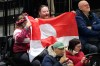 Fans hold Greenland national flag before a preliminary round match of men's ice hockey between United States and Denmark at the 2026 Winter Olympics, in Milan, Italy, Saturday, Feb. 14, 2026. (AP Photo/Hassan Ammar)