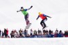 Canada's Eliot Grondin, left, and Austria's Jakob Dusek competes in the mixed snowboard cross team event at the Milano Cortina 2026 Winter Olympic Games in Livigno, Italy on Sunday, Feb. 15, 2026. THE CANADIAN PRESS/Sean Kilpatrick