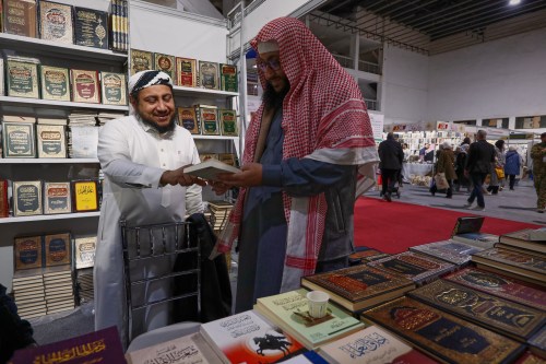 A visitor looks through a book at a stall selling Islamic titles during the 57th Damascus International Book Fair in Damascus, Syria, Monday, Feb. 16, 2026, the first edition since the collapse of the Assad regime. (AP Photo/Omar Sanadiki)