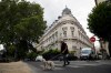FILE - In this Aug.13, 2019 file photo, a man walks his dog next to an apartment building owned by Jeffrey Epstein in Paris. (AP Photo/Francois Mori, File)