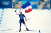 Julia Simon, of France, skis to the finish line with her country's flag for gold in the women's 4x6-kilometer relay biathlon race at the 2026 Winter Olympics in Anterselva, Italy, Wednesday, Feb. 18, 2026. (AP Photo/Andrew Medichini)