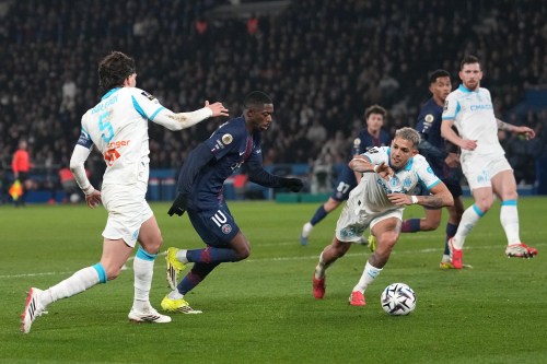 PSG's Ousmane Dembele, second left, challenges for the ball with Marseille's Facundo Medina, right, and Marseille's Leonardo Balerdi during the French League One soccer match between Paris Saint-Germain and Marseille in Paris, Sunday, Feb. 8, 2026. (AP Photo/Thibault Camus)