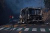 Pedestrians walk past a charred vehicle after it was set on fire, on a road in Cointzio, Michoacán state, Mexico, Sunday, Feb. 22, 2026, after the death of the leader of the Jalisco New Generation Cartel, Nemesio Rubén Oseguera Cervantes, known as 
