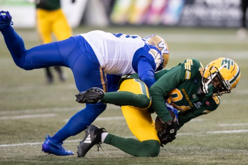 Winnipeg Blue Bombers' Jamal Parker (left) tackles Edmonton Elks' Odieu Hiliare (84) during first half CFL action in Edmonton on Saturday, October 11, 2025. THE CANADIAN PRESS/Amber Bracken