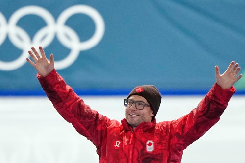 Laurent Dubreuil of Canada celebrate winning the bronze medal on the podium of the men's 500 meters speedskating race at the 2026 Winter Olympics, in Milan, Italy, Saturday, Feb. 14, 2026. (AP Photo/Ben Curtis)