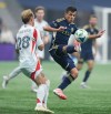 Vancouver Whitecaps' Andres Cubas, right, and FC Dallas' Samuel Sarver vie for the ball during the first half of an MLS soccer match, in Vancouver, on Saturday, October 18, 2025. THE CANADIAN PRESS/Darryl Dyck