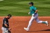 Seattle Mariners' Cal Raleigh runs the bases past Chicago White Sox third baseman Lenyn Sosa after hitting a two-run home run during the third inning of a spring training baseball game Tuesday, Feb. 24, 2026, in Peoria, Ariz. (AP Photo/Charlie Riedel)