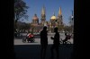 People mill about in the plaza of the Cathedral of the Assumption of Our Lady in the center of Guadalajara, Mexico, Wednesday, Feb. 25, 2026. (AP Photo/Marco Ugarte