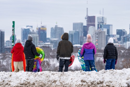 Children prepare to toboggan down a hill following heavy snow in Toronto, Thursday, Feb. 13, 2025. THE CANADIAN PRESS/Arlyn McAdorey