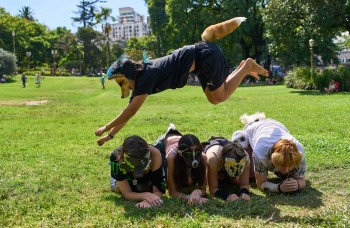 A youth jumps over other therians, people who say they identify as non-human animals, during a gathering in a square in Buenos Aires, Argentina, Sunday, Feb. 22, 2026. (AP Photo/Rodrigo Abd)