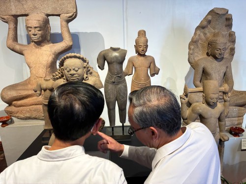 Cambodian officials look at Khmer cultural artifacts that were returned to the country, at the National Museum, in Phnom Penh, Friday, Feb. 27, 2026. (AP Photo/Sopheng Cheang)