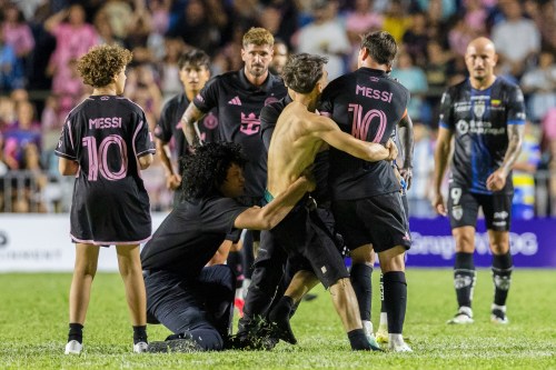 A fan who got onto the field grabs Inter Miami's Lionel Messi at the end of an international friendly soccer match against Ecuador's Independiente del Valle in Bayamon, Puerto Rico, Thursday, Feb. 26, 2026. (AP Photo/Alejandro Granadillo)