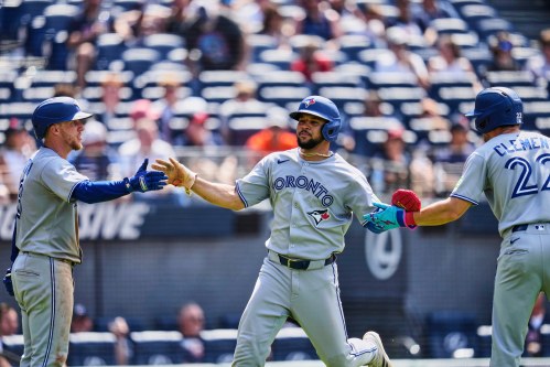 Toronto Blue Jays' Jonatan Clase, center, is greeted by Myles Straw, left, and Ernie Clement (22) after scoring in the ninth inning of a baseball game against the Cleveland Guardians in Cleveland, Thursday, June 26, 2025. (AP Photo/Sue Ogrocki)