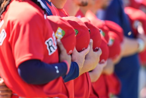 Boston Red Sox players hold their hats to their hearts for the national anthem before a spring training baseball game against the Minnesota Twins in Fort Myers, Fla., Wednesday, Feb. 25, 2026. (AP Photo/Gerald Herbert)