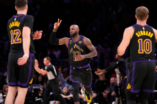 Los Angeles Lakers forward LeBron James, center, gestures after scoring as Los Angeles Lakers forward Jake LaRavia, left, and guard Luke Kennard watch during the first half of an NBA basketball game Tuesday, March 3, 2026, in Los Angeles. (AP Photo/Mark J. Terrill)