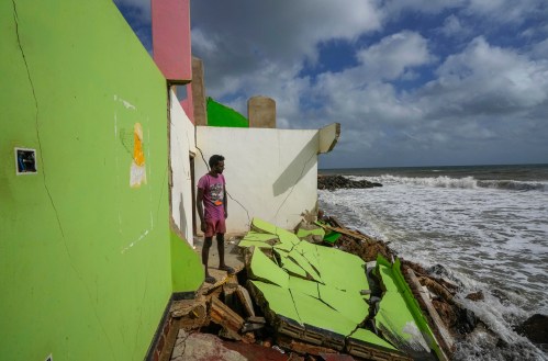 FILE - Dilrukshan Kumara looks at the ocean as he stands by the remains of his family's home in Iranawila, Sri Lanka, June 15, 2023. (AP Photo/Eranga Jayawardena, File)