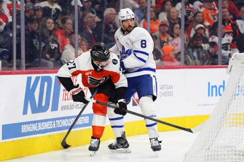 Toronto Maple Leafs' Chris Tanev (8) pressures Philadelphia Flyers' Noah Cates (27) behind the net during the second period of an NHL hockey game, Saturday, Nov. 1, 2025, in Philadelphia. (AP Photo/Derik Hamilton)