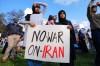 Children hold a sign protesting war against Iran during an antiwar demonstration at Dealey Plaza in downtown Dallas, Sunday, March 1, 2026. (AP Photo/LM Otero)