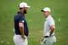 FILE - Jon Rahm, left, of Spain, talks with Rory McIlroy, of Northern Ireland, on the practice range during a practice round in preparation for the Masters golf tournament at Augusta National Golf Club Tuesday, April 9, 2024, in Augusta, Ga. (AP Photo/Charlie Riedel, File)