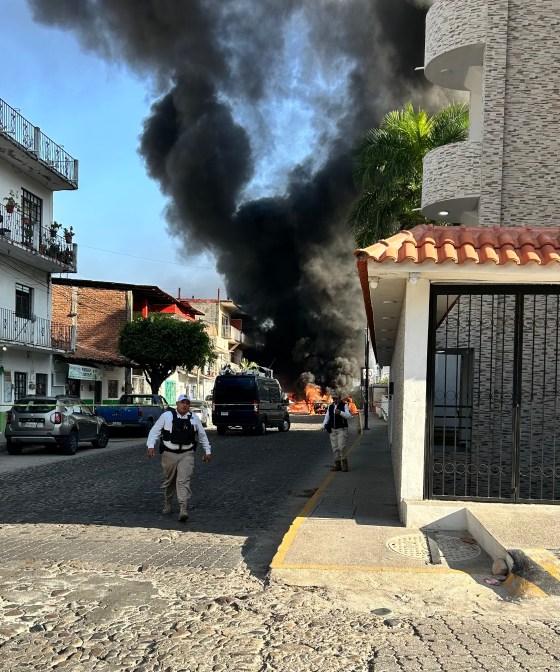 Tracey Seida and Jerry Buckland captured this image of smoke and flames from car fires near their vacation rental in Puerto Vallarta, Mexico on Sunday. (Supplied)