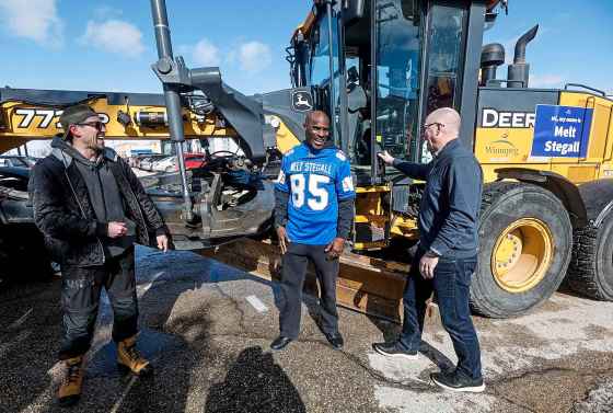 MILT MEETS ‘MELT’: Mayor Scott Gillingham (right) and operator Steve Moreira introduce former Blue Bomber Milt Stegall Sunday to the snow grader ‘Melt Stegall’ during an autograph session at CanCentral Sports Cards & Memorabilia. The city held a competition earlier this year to name its snow-clearing equipment. (John Woods / Free Press)