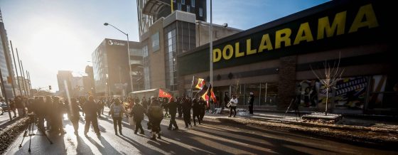 People protest outside the Dollarama on Portage Avenue on Monday afternoon. (John Woods / Free Press)