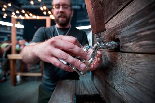 JUSTIN SAMANSKI-LANGILLE / WINNIPEG FREE PRESS Brian Westcott of Barn Hammer Brewing Company pours a sample Saturday at the Flatlander&rsquo;s Beer Festival at the MTS Centre. 170610 - Saturday, June 10, 2017.
