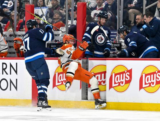 Anaheim Ducks’ Mikael Granlund (64) is checked by Winnipeg Jets’ Adam Lowry (17) during the first period of Tuesday's game. The Ducks won 4-1. (Fred Greenslade / The Canadian Press files)