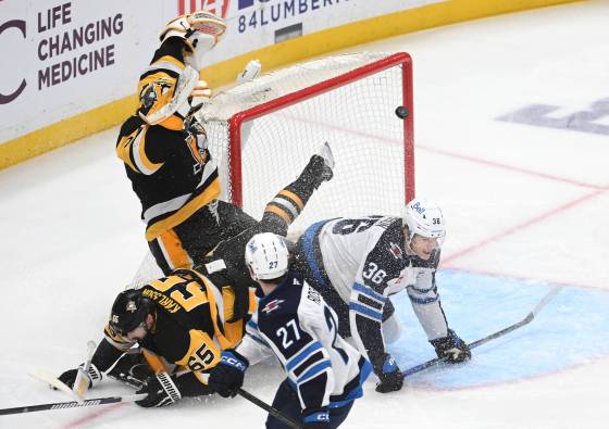 Winnipeg Jets centre Morgan Barron (36) scores on Pittsburgh Penguins goalie Arturs Silovs (37) while crashing into defenceman Erik Karlsson (65) as right wing Isak Rosen (27) looks on during the first period on Saturday in Pittsburgh.(Philip G. Pavely / The Associated Press)